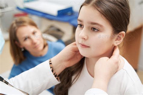 Female Doctor Examining Child Lymph Nodes In Clinic Stock Photo By