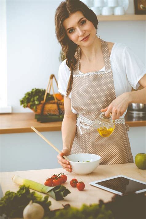 Young Brunette Woman Cooking In Kitchen Housewife Holding Wooden Spoon In Her Hand Stock Image