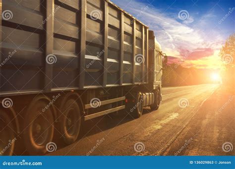 Truck With A Container Driving On The Countryside Road Against Night