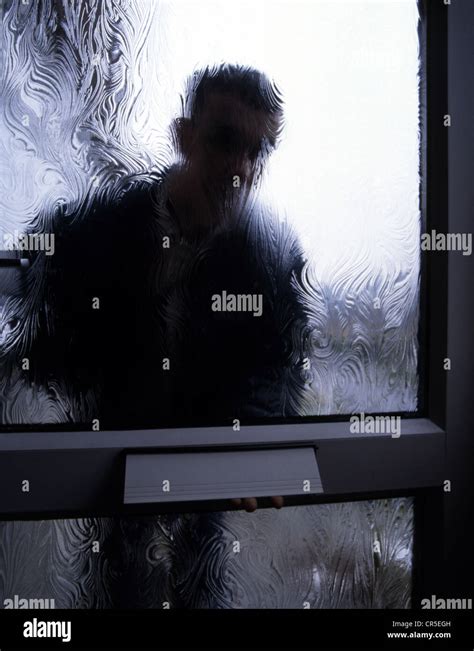 Silhouette Of A Man Behind A Frosted Glass Door Outside Looking In