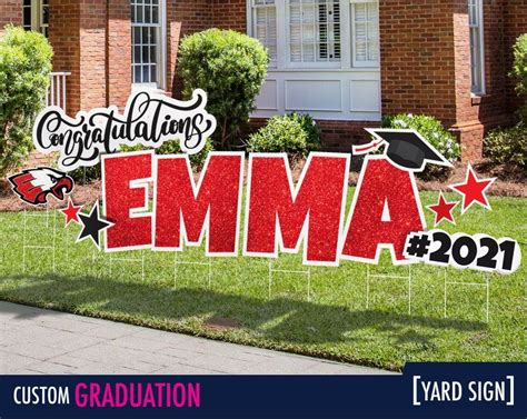A Graduation Yard Sign In Front Of A Brick House With The Words Ema On It