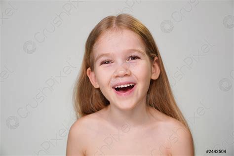 A Cheerful Little Girl With Blond Hair Is Laughing Stock Photo