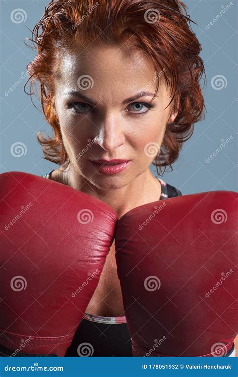 Studio Portrait Of Sporty Mature Woman In Boxing Gloves On Gray