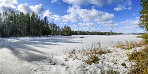 A Scenic View Of Sun Lit Cloudscape Over A Frozen Lake Surrounded By