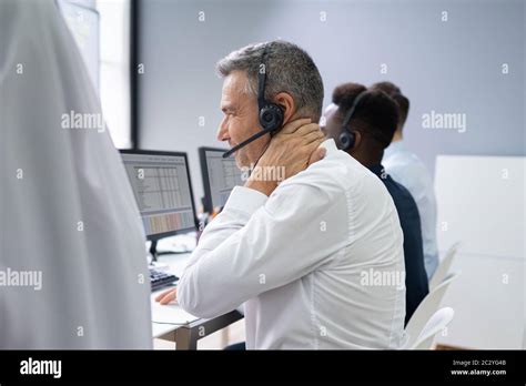 Mature Businessman Suffering From Neck Pain At Work Stock Photo Alamy
