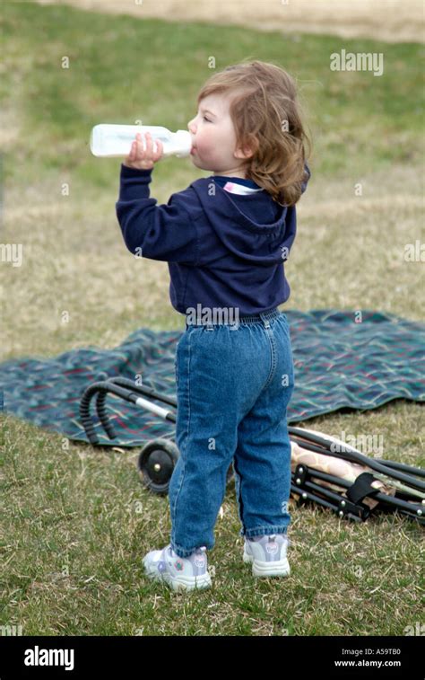 2 Year Old Baby Girl Drinks Mild Formula From A Baby Bottle Stock Photo