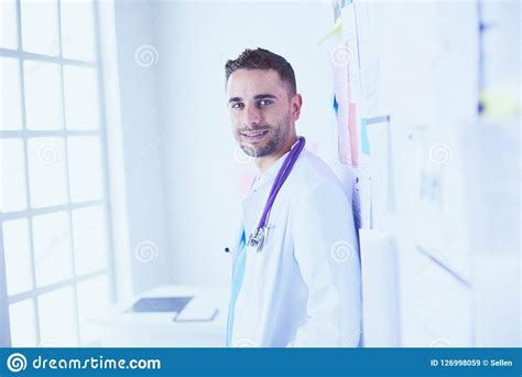 Young And Confident Male Doctor Portrait Standing In Medical Office