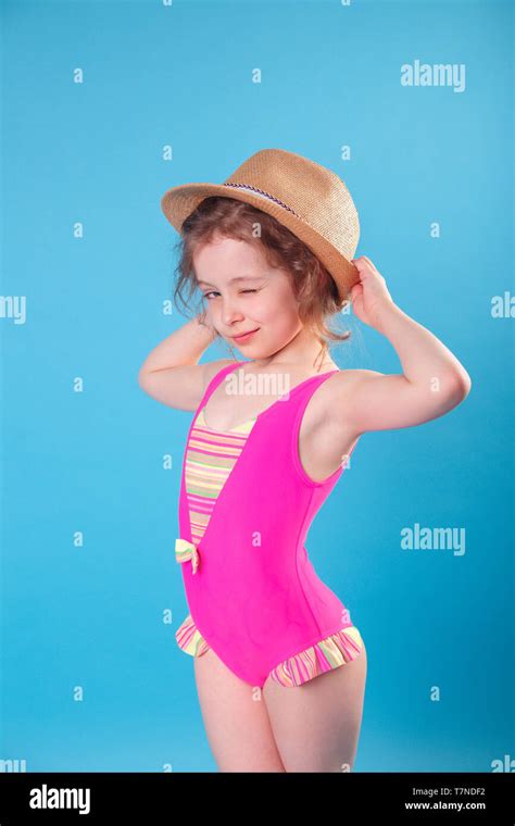 Süße Kleine Mädchen In Badeanzug Und Hut Lächelnd An Kamera Auf Blauem Hintergrund