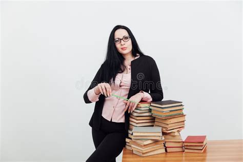 A Woman Brunette In A Business Suit Teacher With Stacks Of Books Stock