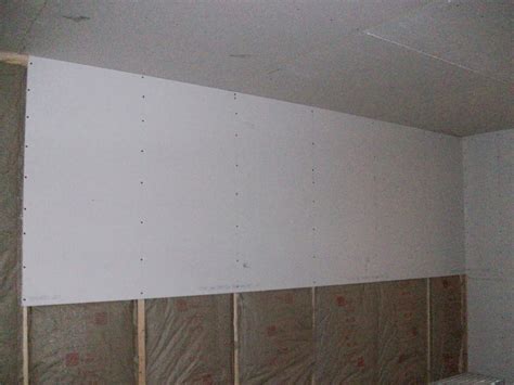 Shows lifting a small ceiling sheet rock panel. Barndominium: Sheetrock