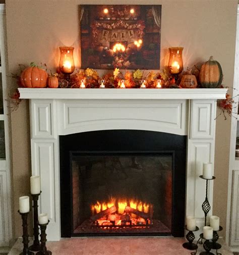 A Fireplace With Candles And Pumpkins On It