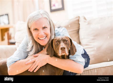 Caucasian Woman Hugging Dog On Sofa Stock Photo Alamy