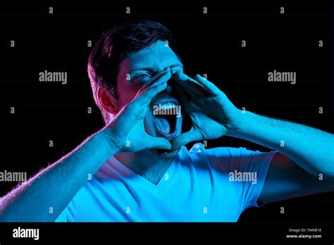 Angry Man Screaming Over Neon Lights In Dark Room Stock Photo Alamy