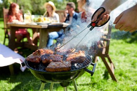 Man Cooking Meat On Barbecue Grill At Summer Party Stock Photo Image