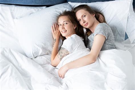 Two Smiling Lesbians Embracing While Lying In Bed Stock Image Image