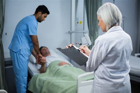Doctor And Surgeon Consulting Patient In Ward Stock Photo Image Of