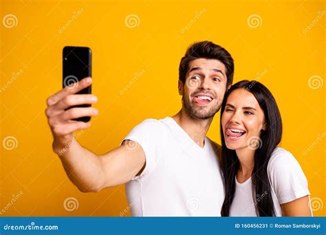 Photo Of Two People Holding Telephone Taking Selfies Sticking Tongues Out Of Mouth Playful Mood
