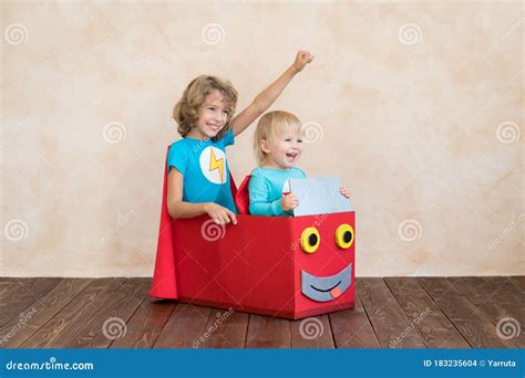 Superhéroes Niños Jugando En Caja De Cartón Foto De Archivo Imagen De