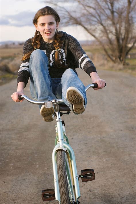A Young Teen Girl Rides Bike With Feet On Handle Bars By Tana Teel