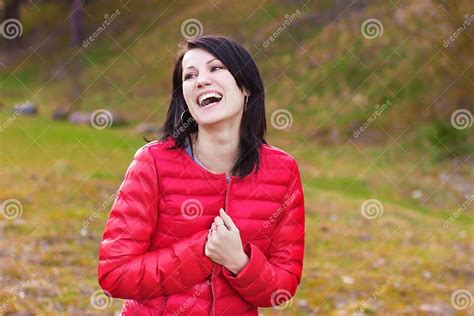 Beautiful Happy Girl With Perky Smile In Red Jacket Is In The Forest