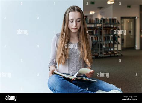 Teenage Girl Reading Book In A Public Library Stock Photo Alamy