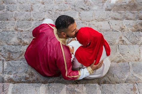 High Angle Photo Of An Arab Man Kissing His Muslim Girlfriend On The