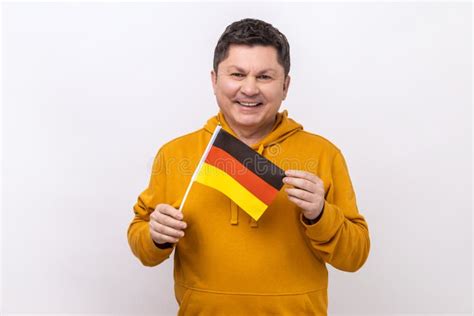 Middle Aged Man Holding German Flag In Her Hand And Looking At Camera