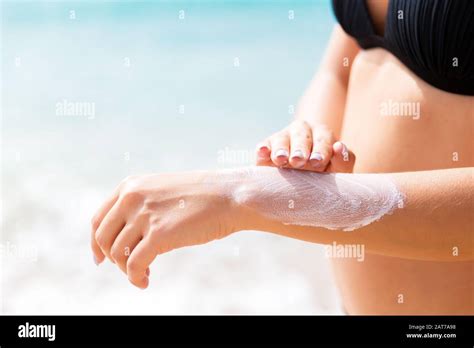 Pretty Girl Is Putting Sun Lotion On Her Hand At The Beach Stock Photo Alamy