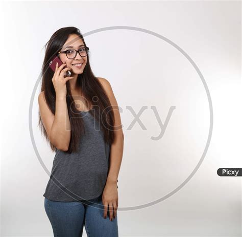 Image Of An Attractive Latina Wearing Glasses And A Grey Shirt Smiles