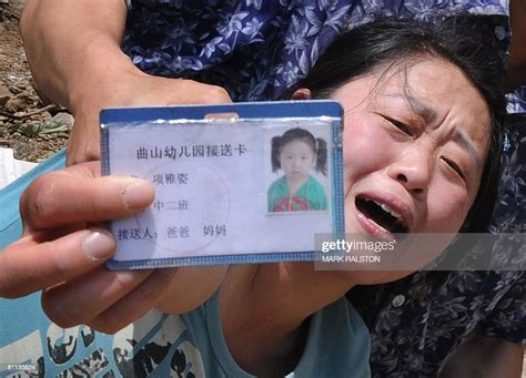 A Chinese Woman Cries As She Shows The Identity Card Of Her Dead