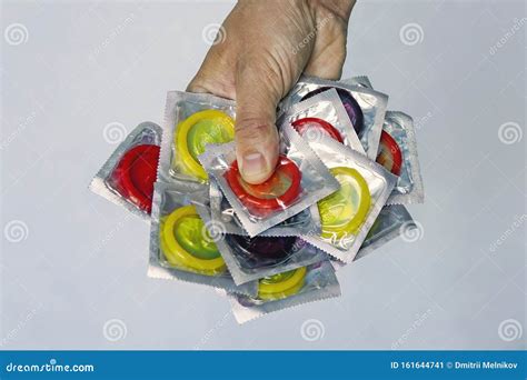 Safe Sex Concept Hand With Condom A Large Number Of Colorful Condoms