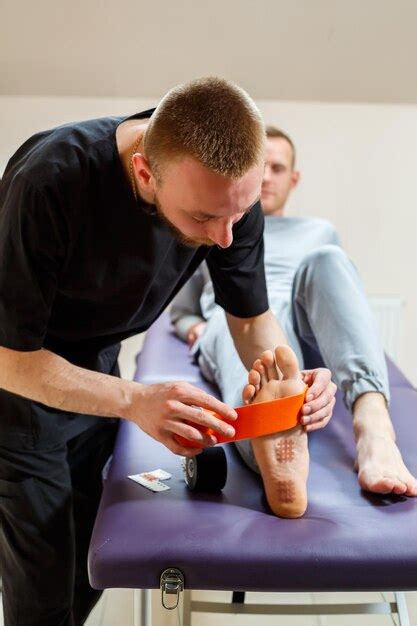 Premium Photo Male Physiotherapist Doctor Massages The Feet Of A Relaxed Man Sitting On A