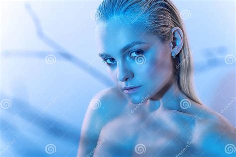 Beautiful Blond Model With Nude Make Up Slicked Back Hair And Naked Shoulders In Blue Light