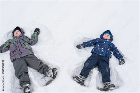 Two Little Siblings Kid Boys In Colorful Winter Clothes Making Snow