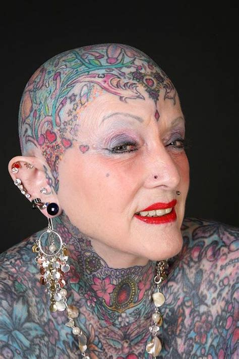 A Woman With Tattoos And Piercings On Her Head