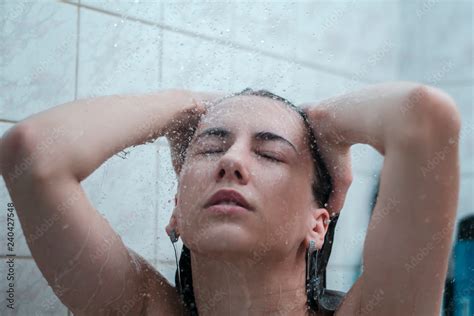 Young Naked Girl Under The Shower In The Foam Water Runs Down The Face