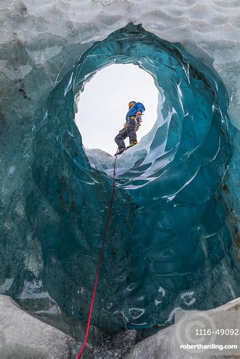Man Exploring An Ice Cave Stock Photo