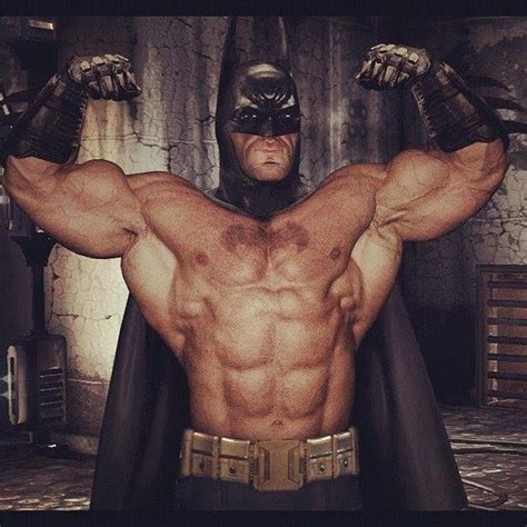 A Man In A Batman Costume Is Flexing His Muscles