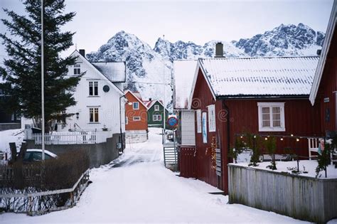 Typical Scandinavian Red Houses At Fjord In Front Of Snow Covered