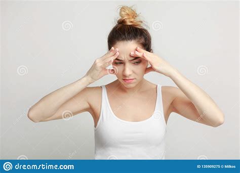 Exhausted Woman Suffering From Headache Over Gray Background Stock