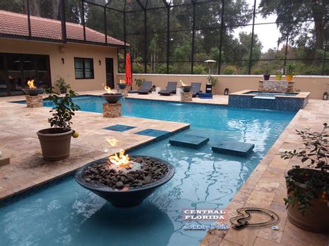 an outdoor swimming pool with fire pit and seating area