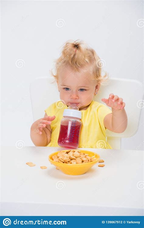 Cute Little Baby Girl 1 Year Old Eating Cereal Flakes And Drinking