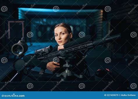Serious Cute Shooter With Her Firearm Sitting At The Table Stock Image