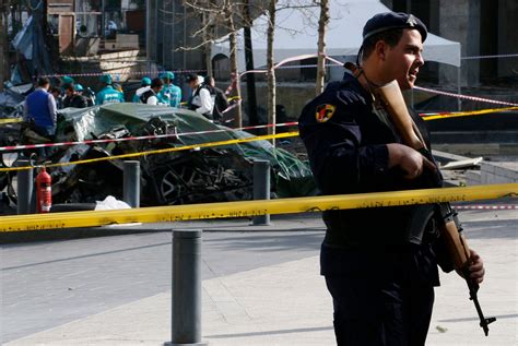 A Policeman Stands Guard At The Site Of A Bomb Blast Which Killed