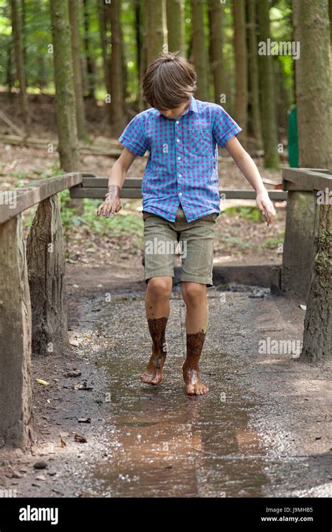 Boy Walking Through Mud At Barefoot Trail Egestorf Lower Saxony Stock