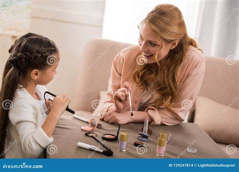 Beautiful Happy Mother And Little Daughter Applying Makeup Together