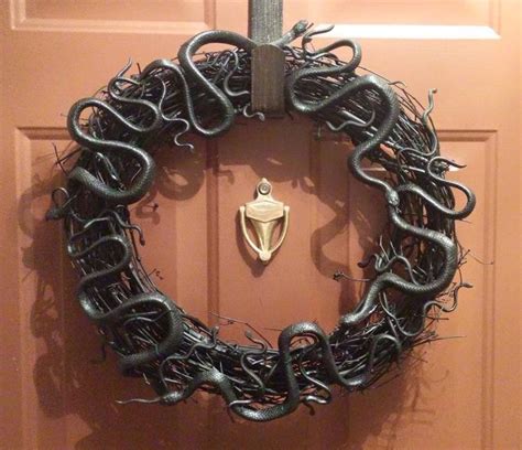 A Door With A Wreath Made Out Of Metal Snakes On The Front And Side Of It