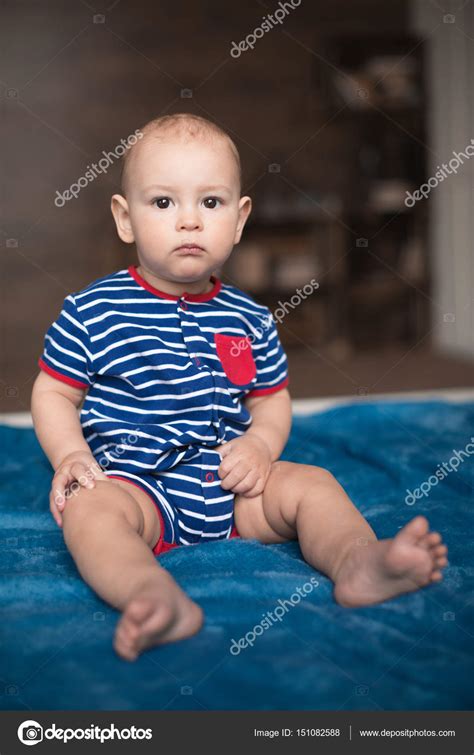 Cute Baby Boy Sitting On Bed — Stock Photo © Lenamiloslavskaya 151082588