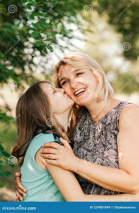 Une Adolescente Embrasse Sa Mère Sur La Joue Dans La Nature En été Image Stock Image Du