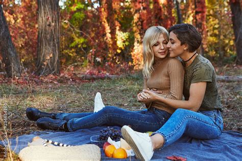 a beautiful happy couple of lesbian ladies having a romantic picnic in the park the blonde and